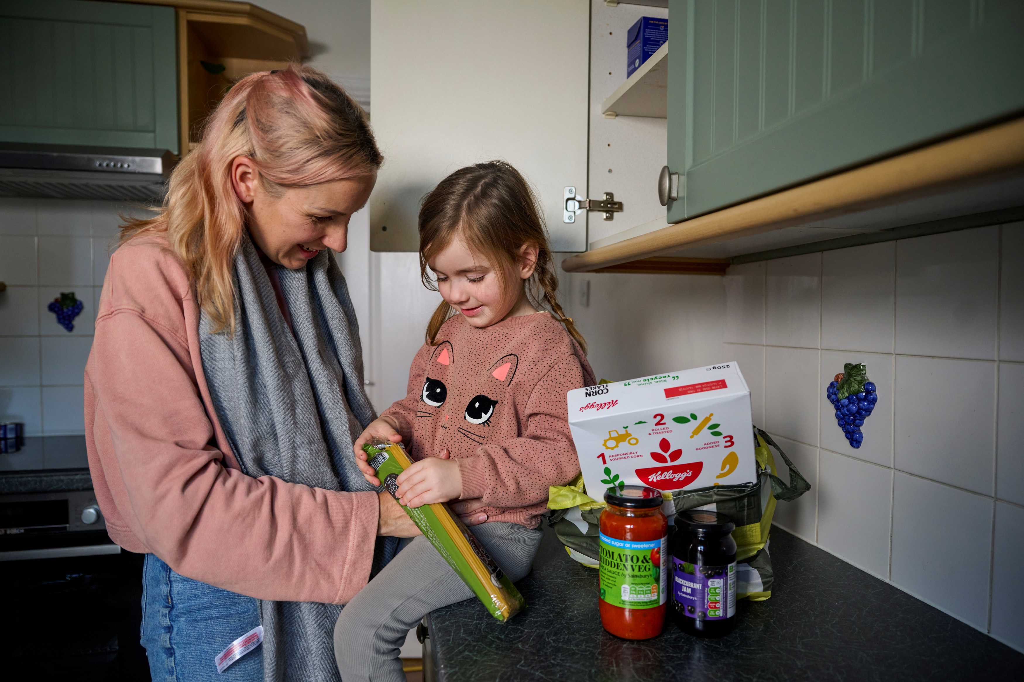 Mother and child sit in kitchen with food